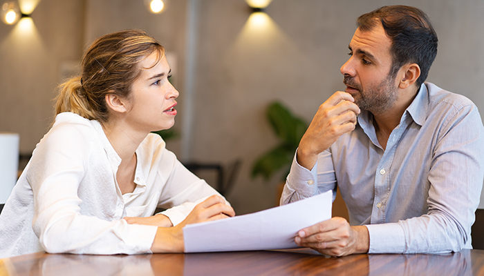 Giving Constructive Feedback to Your Staff (Male and Female Discussing Report)