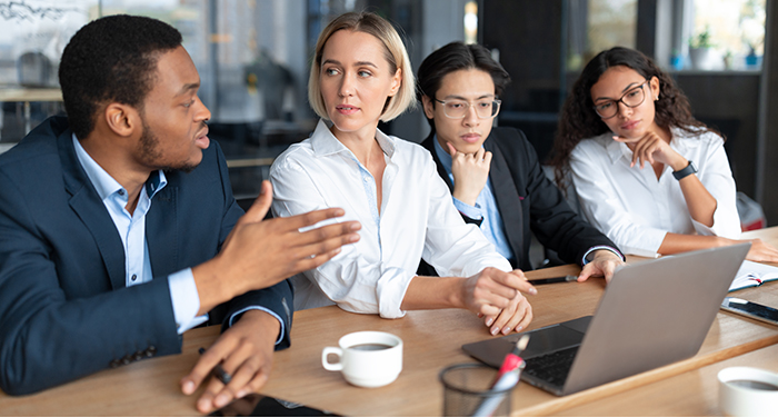 Business meeting with male boss and three female employees at conference table